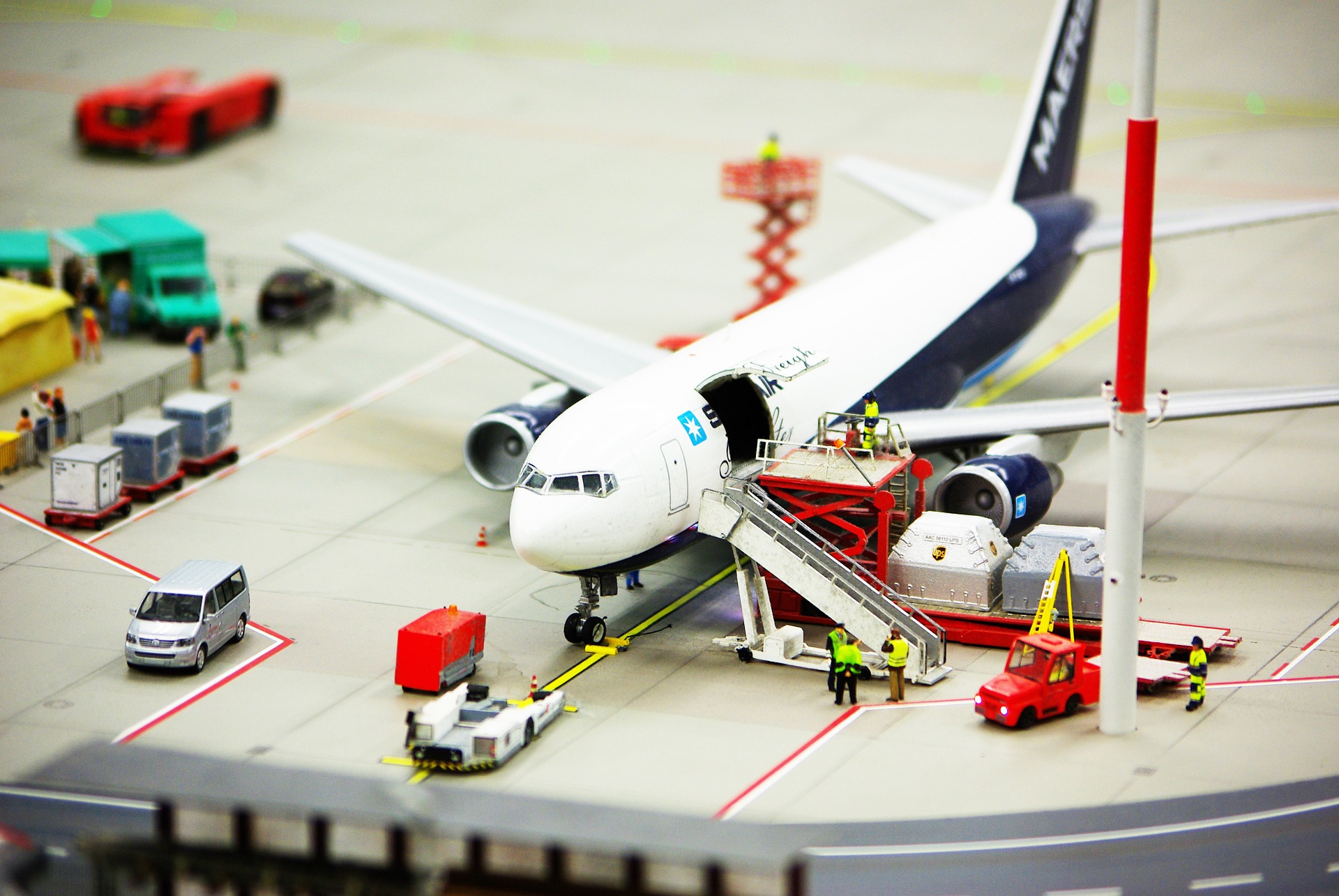 A bird's eye view of a scissor lift pallet truck in action in an airport. 